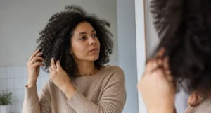 Cheveux mousseux : 5 gestes pour les dompter au naturel Conseils pratiques pour savoir comment dompter cheveux mousseux avec des soins naturels dans une salle de bain lumineuse.
