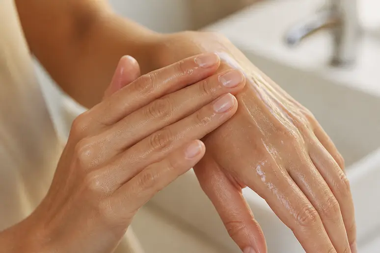 Mains émulsionnant une huile nettoyante avec de l'eau tiède pour le double nettoyage du visage