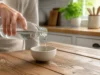Le vinaigre blanc tue-t-il les poux ou juste les lentes ? Un flacon de vinaigre blanc et poux sur le comptoir d'une cuisine lumineuse pour un traitement naturel