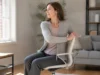 Yoga sur chaise : 4 exercices faciles pour dos et nuque Femme pratiquant le yoga sur chaise exercices faciles pour détendre le dos dans son salon lumineux.