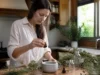 Huile essentielle de ravintsara : bienfaits ORL et sur la peau Flacon d'huile essentielle de ravintsara bienfaits posé sur un plan de travail en bois avec des herbes fraîches