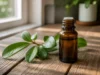 Huile essentielle pour torticolis : gaulthérie pure ou diluée ? Flacon d'huile essentielle pour torticolis posé sur une table en bois avec des feuilles fraîches