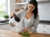 Indiva System avis perte de poids : que valent ces gélules ? Femme préparant une boisson chaude en cuisine pour l'article Indiva System avis perte poids