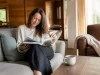 Le magazine Psychologie Positive et son abonnement bimestriel Une femme feuillette un magazine bien-être dans son salon lumineux lors d'un psychologie positive magazine abonnement