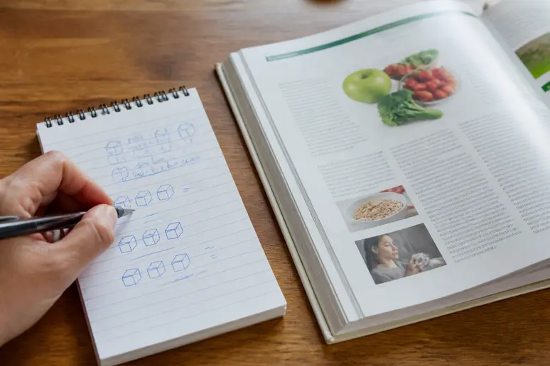 Un carnet de notes posé sur une table présente les seuils recommandés pour un régime sans sucre