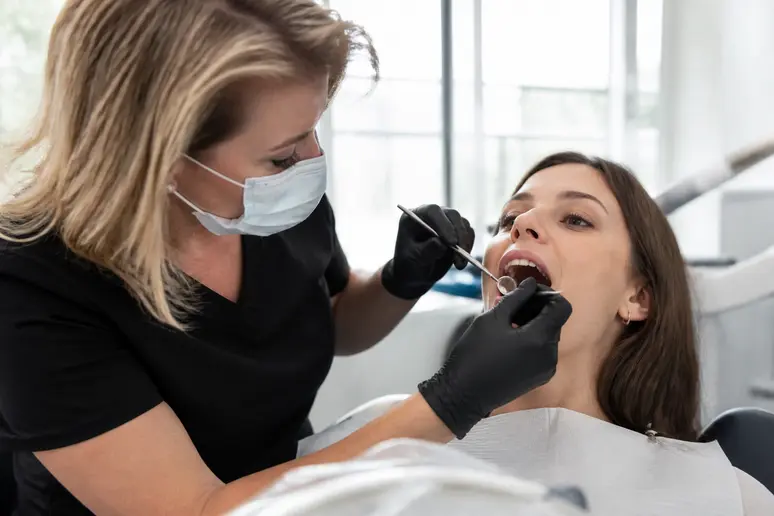 Examen clinique bucco-dentaire réalisé avec un miroir pour contrôler l'état de l'émail